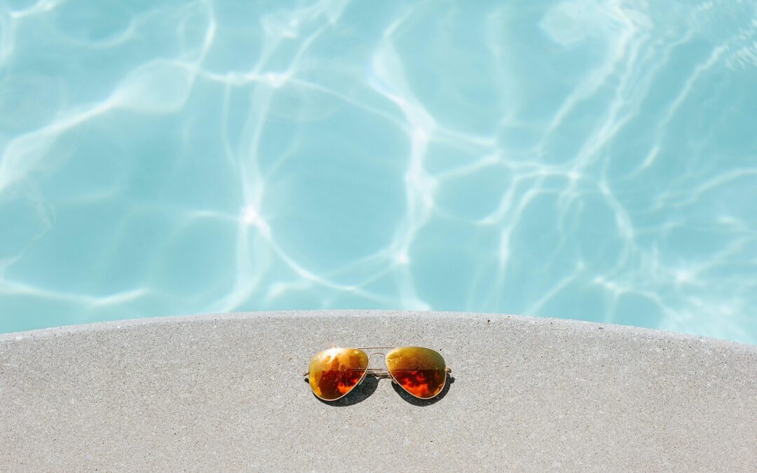 Lunettes de soleil sur le bord d'une piscine.