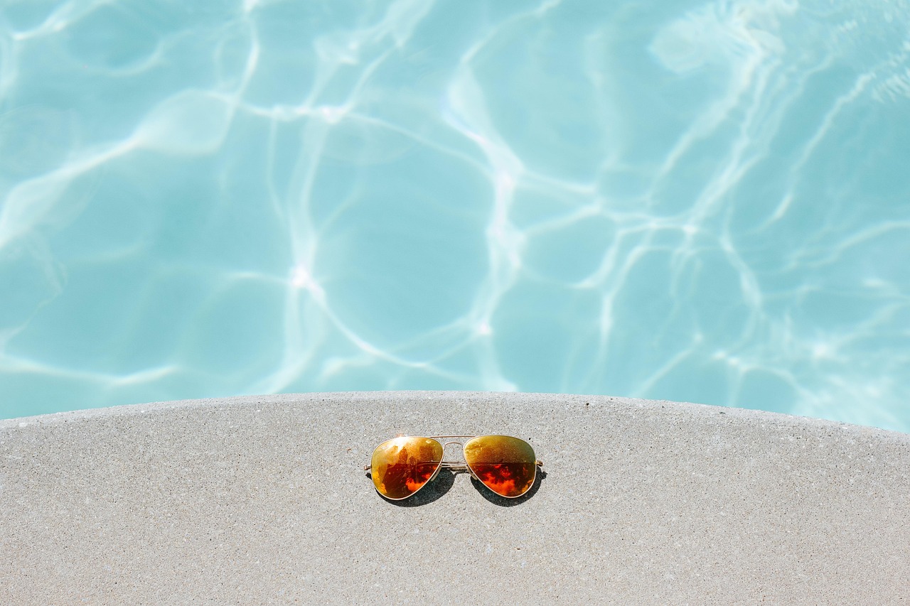 Lunettes de soleil sur le bord d'une piscine.